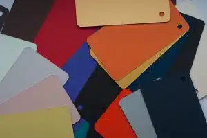 Muestras de tela en azul pastel sobre piel bronceada en superficie blanca minimalista
