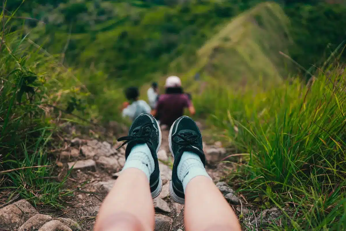Mujer estirando en un descanso durante la caminata en la montaña