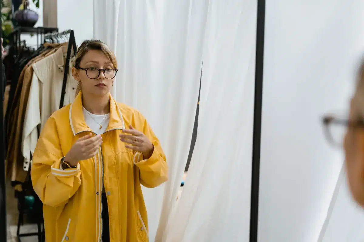 Persona probándose una chaqueta de cuadros frente a un espejo