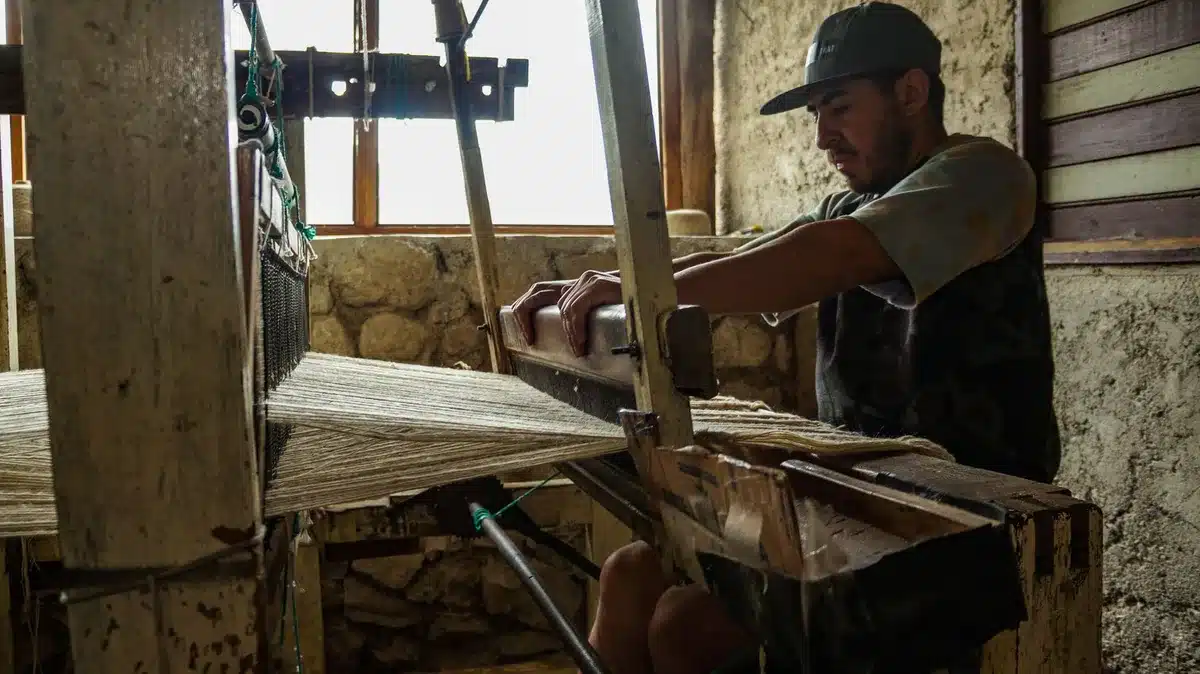 Prendas de lino dobladas y zapatos cómodos en un taller artesanal con luz natural
