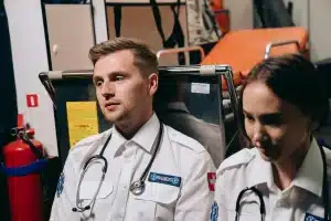 Personal sanitario en urgencias saturadas atendiendo a múltiples pacientes en condiciones de colapso