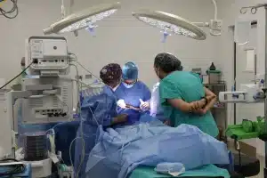 Sala de emergencias abarrotada con enfermeras atendiendo múltiples pacientes simultáneamente