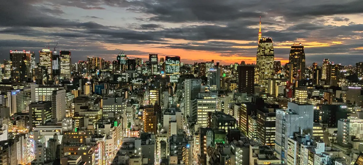 Horizonte urbano iluminado al atardecer con rascacielos y luces de neón