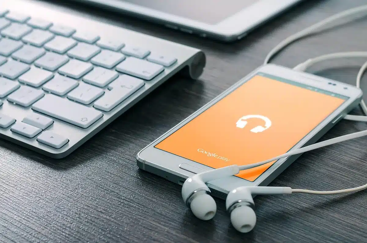 Manos extendidas hacia un teléfono en mostrador con cartel de agotado de fondo