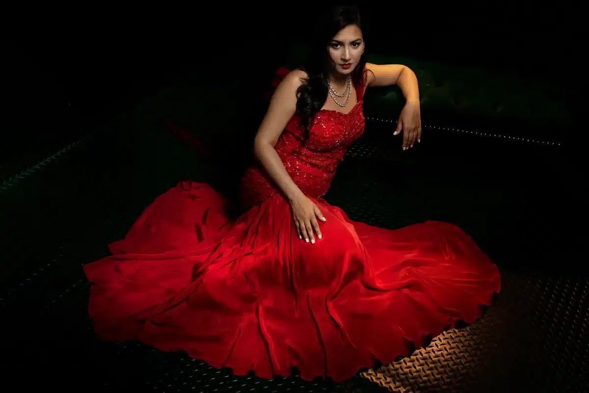 Mujer con vestido de gala elegante en alfombra roja de ceremonia formal.