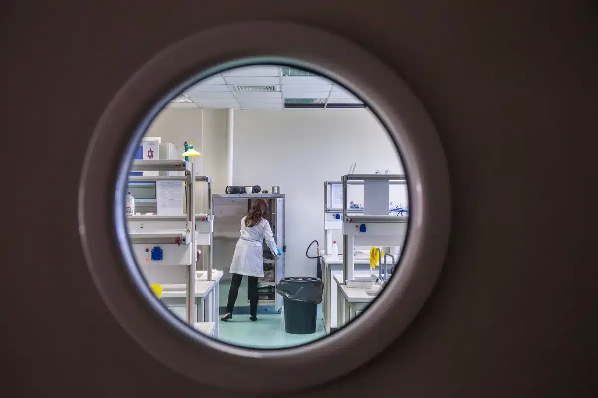 Laboratorio futurista con puerta o portal que brilla entre máquinas tecnológicas