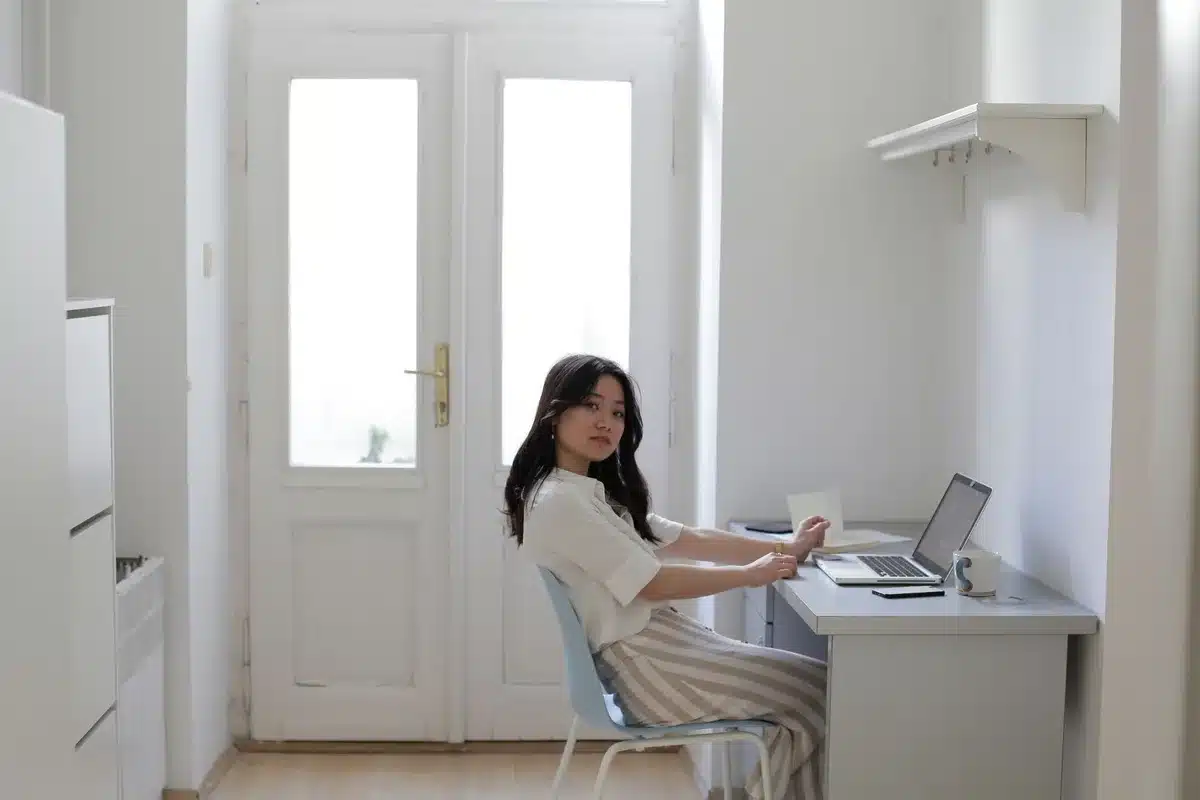 Mujer vistiendo pantalón de rayas con camisa de lino neutra y mocasines para look profesional