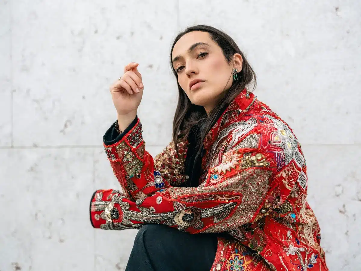 Chaqueta con bordados de colores sobre fondo neutro, detalle artesanal de moda.