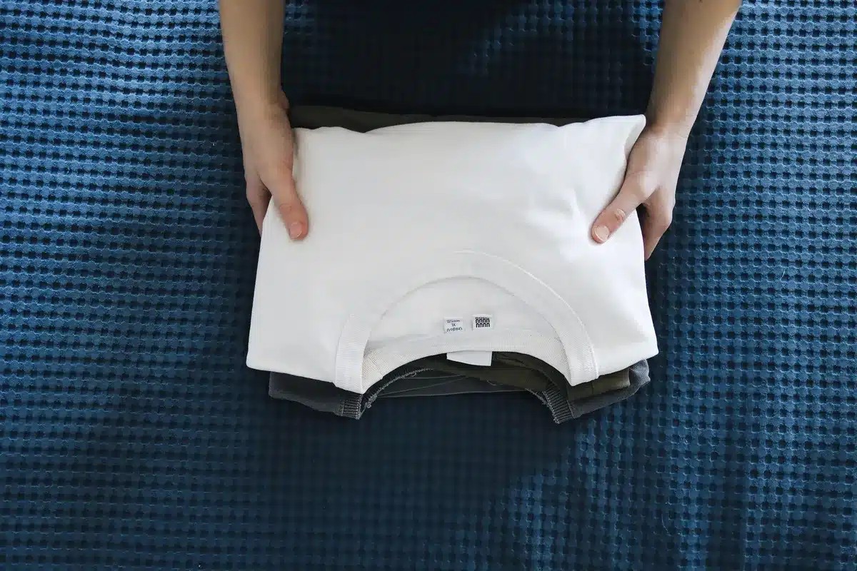 Camisa blanca bien cortada sobre una superficie neutral, mostrando la calidad y el corte estructurado de la prenda.