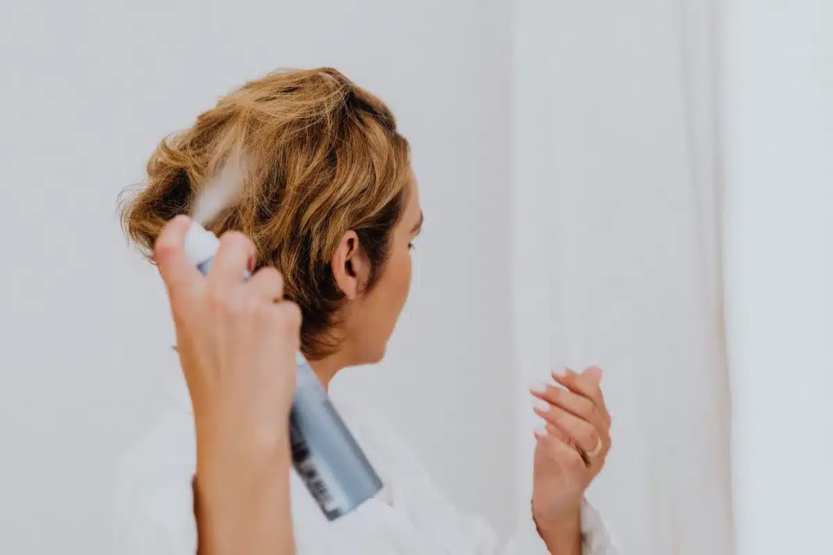 Mujer masajeando cabello tras aplicar spray texturizante