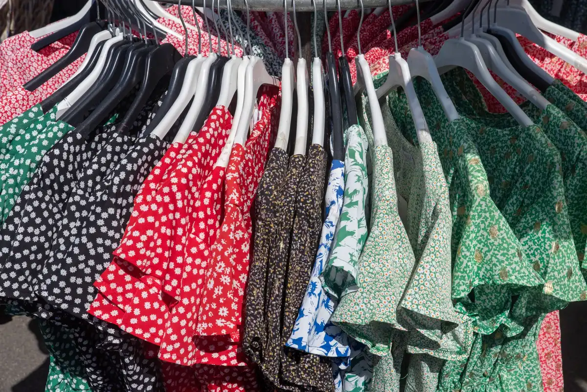 Percha con diferentes vestidos de colores en una tienda de moda mostrando nuevas colecciones.