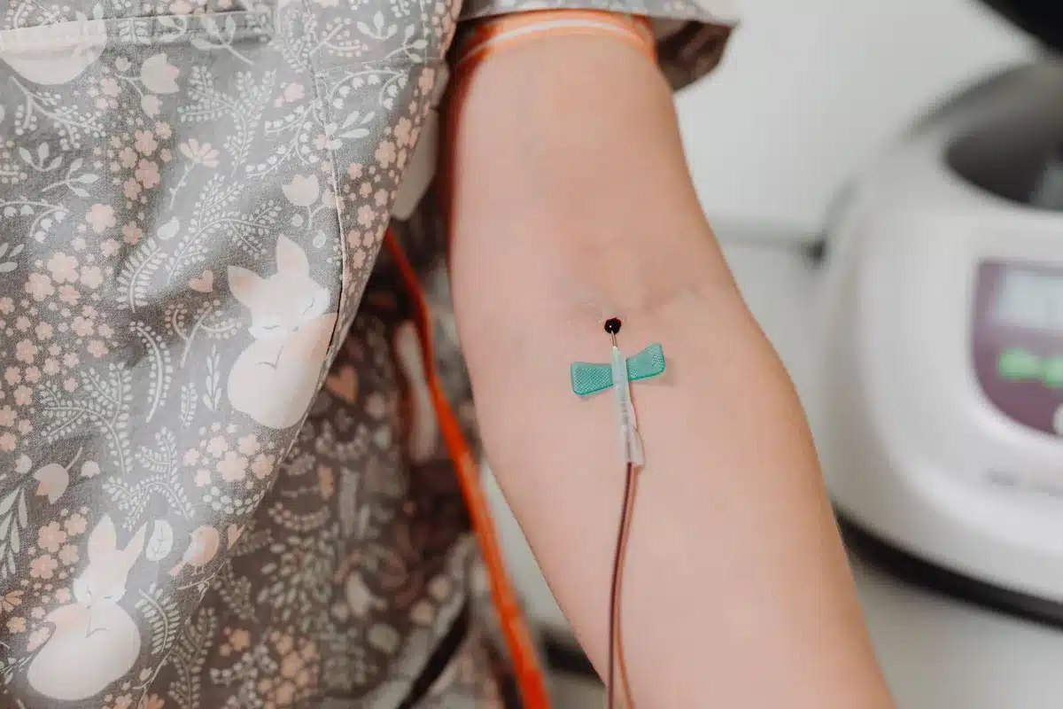 Detalle de una vía intravenosa periférica insertada en el brazo de una paciente