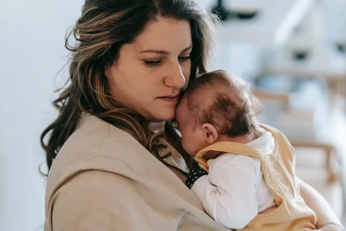 Madre sosteniendo al recién nacido en brazos durante las primeras horas posparto en la maternidad