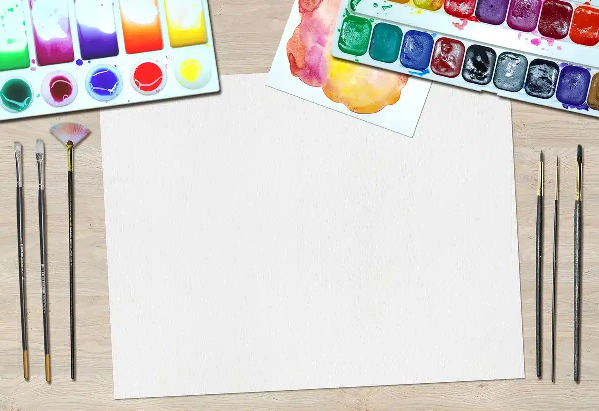 Manuscrito y cuaderno sobre una mesa junto a una lámpara tenue