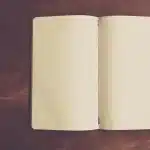 Manos de enfermera apuntando en un cuaderno en una consulta iluminada