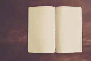 Manos de enfermera apuntando en un cuaderno en una consulta iluminada