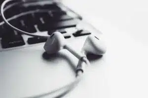 Auriculares inalámbricos compactos junto a un estuche alargado sobre una mesa