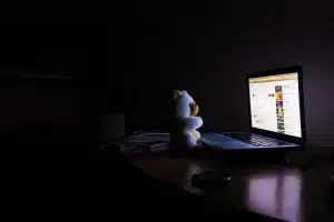 Persona despierta en la cama de noche, con las manos en la cara, expresando frustración por el insomnio
