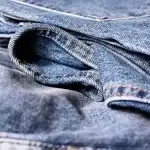 Manos y tejidos en una pasarela borrosa que sugieren moda y textura
