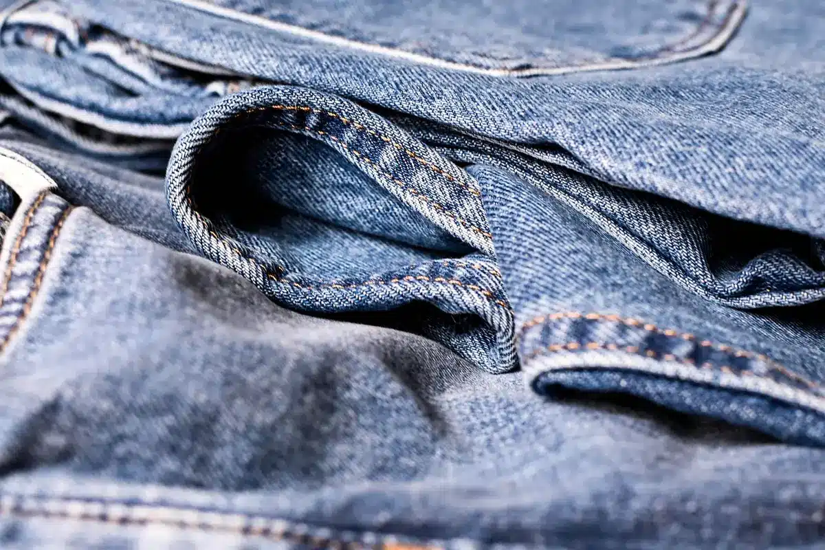 Manos y tejidos en una pasarela borrosa que sugieren moda y textura