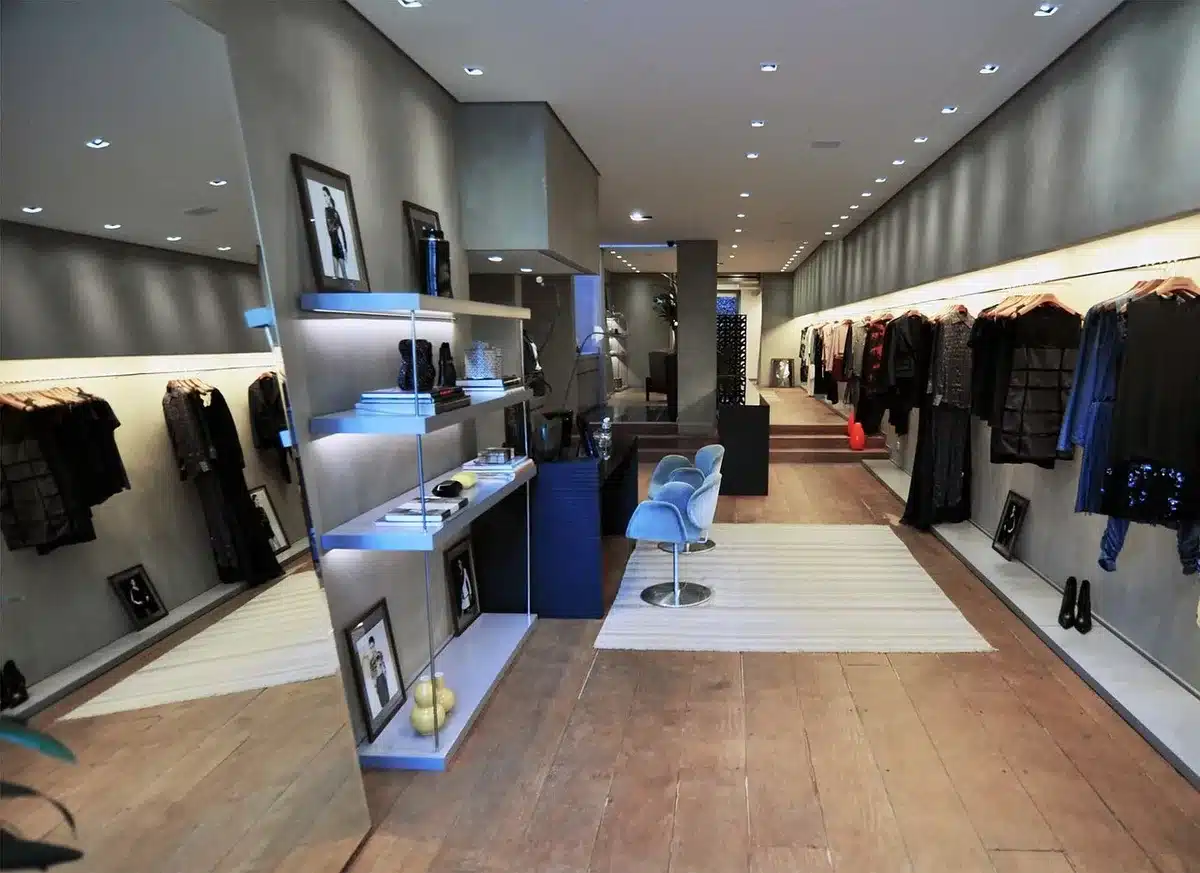 Exhibición de prendas de mujer en tienda con etiquetas de rebaja y descuentos.