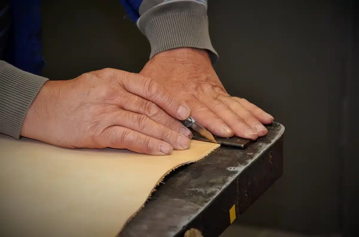 Interior de taller textil con telar y manos trabajando fibras