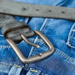 Probador con vaqueros barrel, botas y gabardina preparando looks de otoño