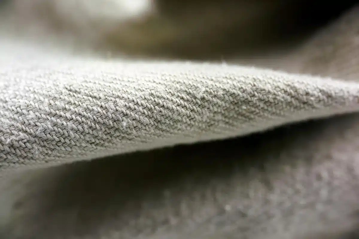 Muestras de tweed y sedas superpuestas mostrando texturas y paleta de colores