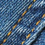 Manos anónimas sosteniendo muestras de tejidos y tweed, detalle de texturas