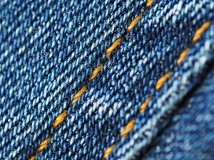 Manos anónimas sosteniendo muestras de tejidos y tweed, detalle de texturas