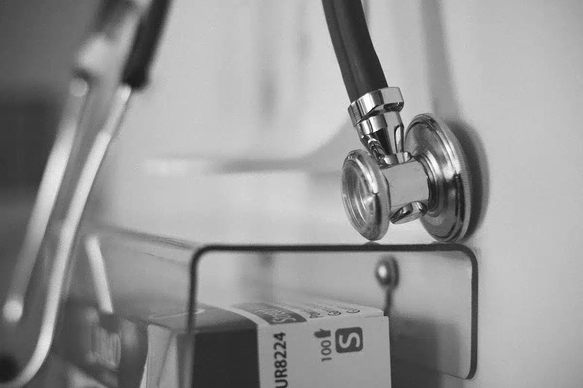 Enfermera hablando con un paciente en sala, tono de voz calmado y escucha activa