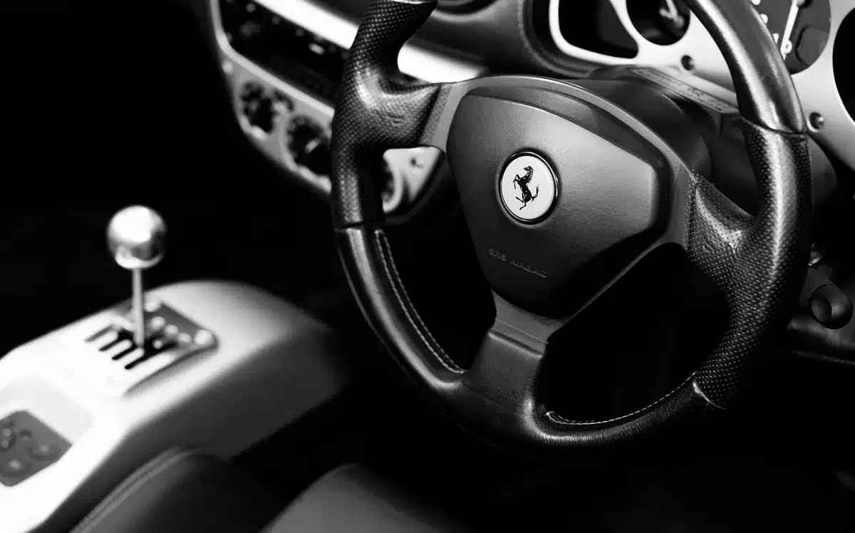 Interior de coche con teléfono en modo CarPlay y manos en el volante