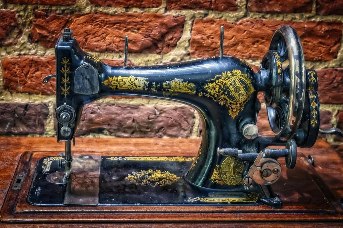 Mano de artesano cosiendo una costura fina en un traje