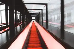 Pasarela semicircular iluminada con estructuras geométricas y telas translúcidas