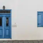 Pasillo suburbano con un teléfono antiguo y una puerta al fondo, ambiente inquietante