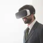 Manos anónimas sosteniendo un casco VR junto a documentos de patentes en una mesa