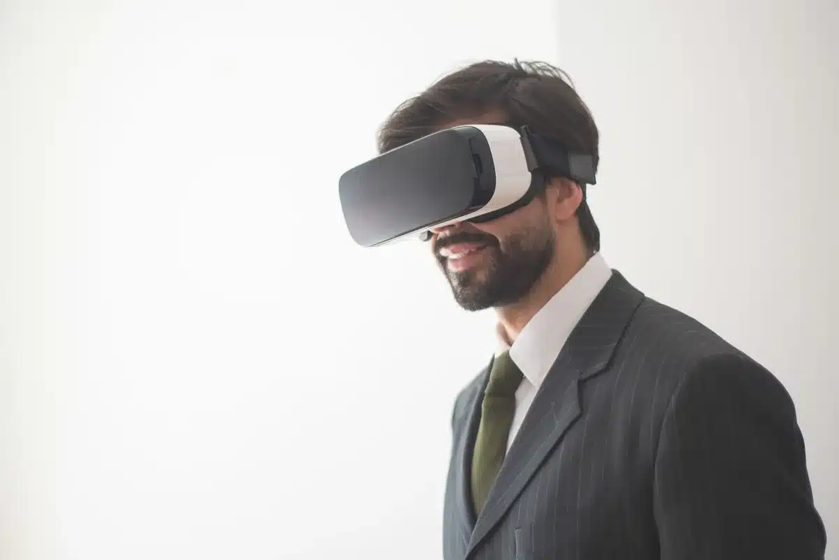 Manos anónimas sosteniendo un casco VR junto a documentos de patentes en una mesa