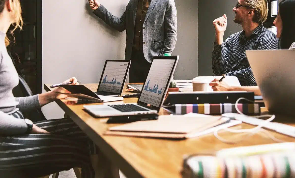Manos anónimas con carpetas y portátil en mesa de trabajo clínico