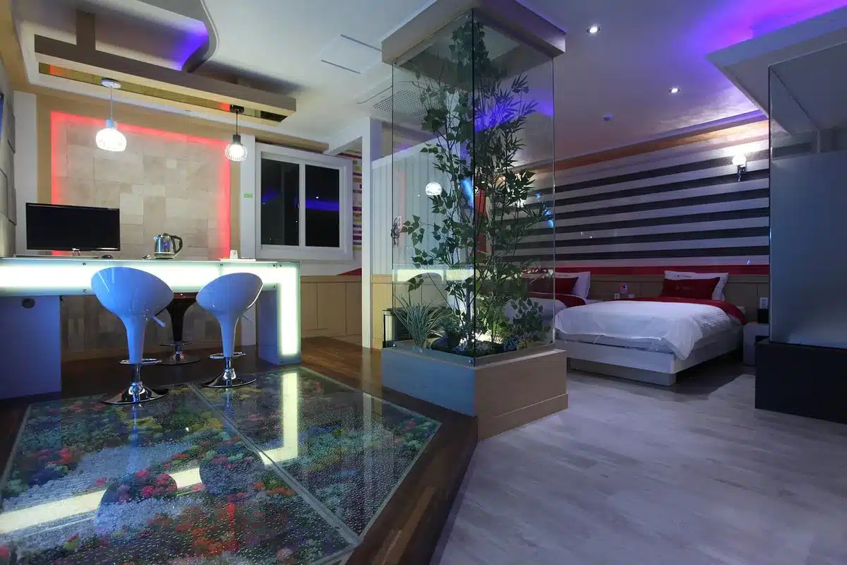 Interior de motel con luces de neón y atmósfera decadente que evoca cine de explotación