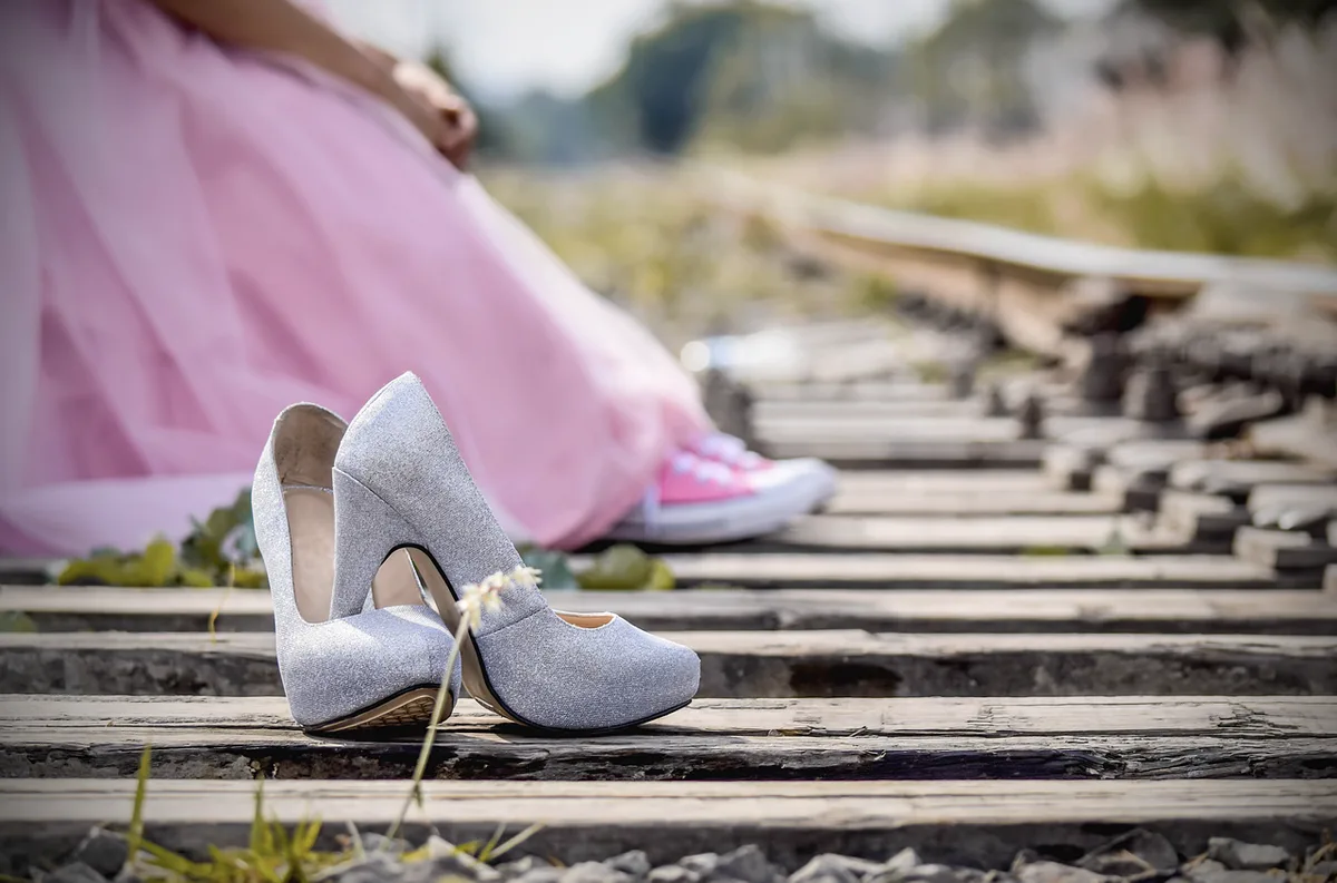 Mano midiendo la altura de la cuña con una regla sobre una zapatilla